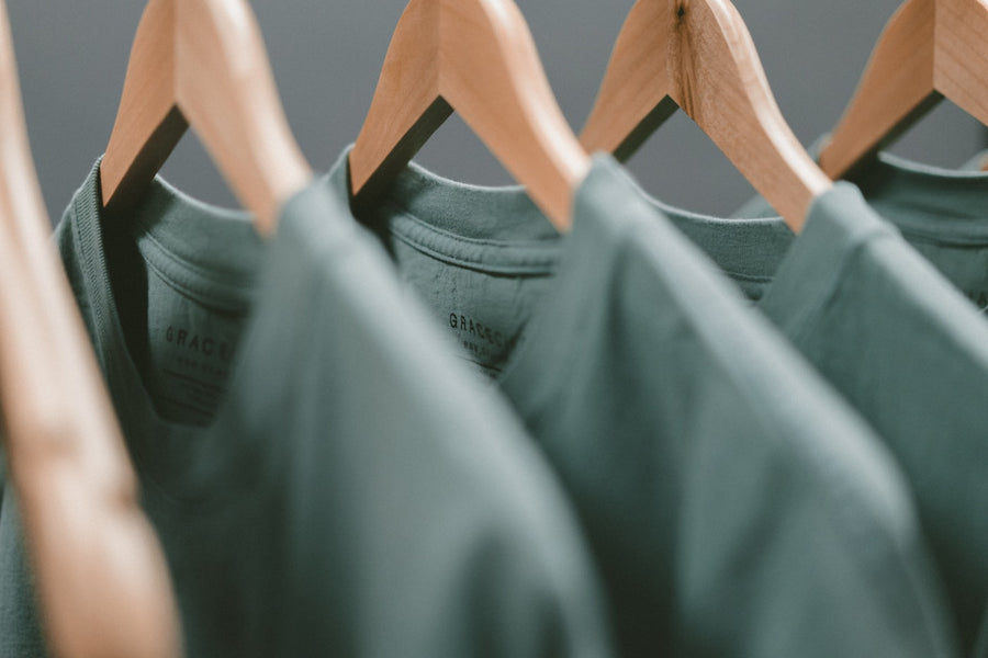 Natural fiber tees on wooden hangers