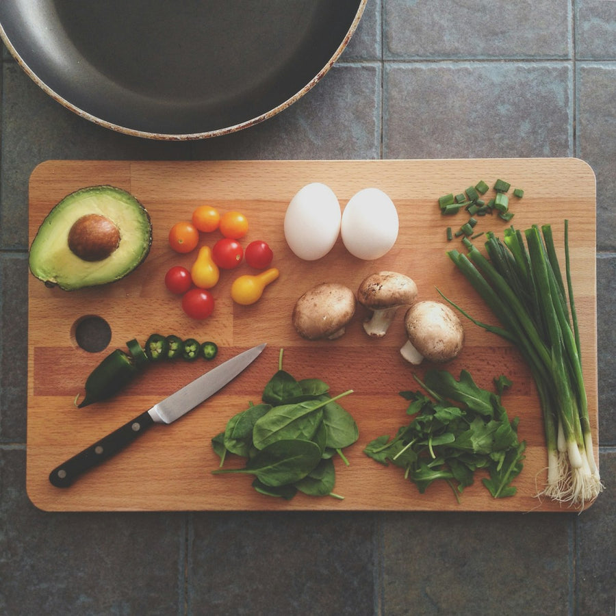 Wooden cutting board with fresh ingredients and cast iron pan